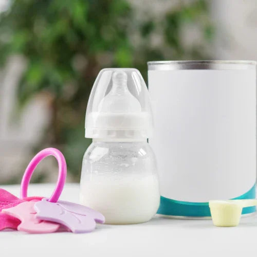 Baby bottle with milk, infant formula canister, pink and purple baby teethers on white surface