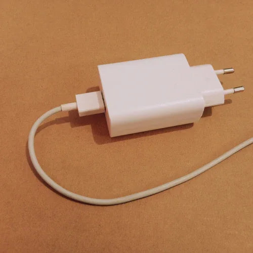White European plug USB wall charger with attached charging cable on brown surface