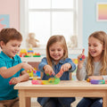 Three children playing with colorful spring toys at a wooden table in a bright playroom